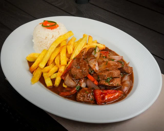 Carne salteada con arroz y papas fritas
